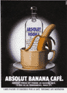 Bottle with a coffee cup in front of it that has a banana in it.