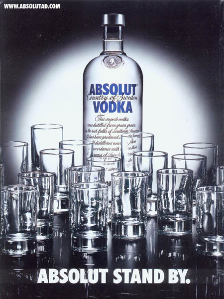 Bottle with shot glasses standing all around.